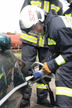 Autó oldalát vágja hidraulikus mentőszerszámmal egy tűzoltó