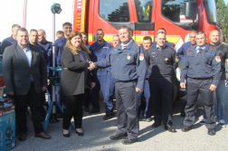 Benke Dávid Dénes tűzoltóparancsnok kezet fog a Makita képviselőjével mögöttük tűzoltók