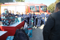 Tűzoltóautó előtt tűzoltók és az eszközök