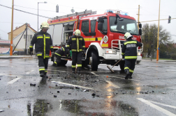 Középen tűzoltóautó előtte az eőss burkolatot söprik le tűzoltók