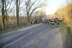 Távolból a baleset helyszíne az úton tűzoltóautók az árokban a fa takarásában az autó