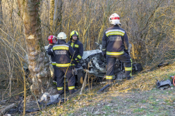 Tűzoltók egyeztetnek az összeroncsolódott autó előtt