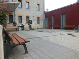 Épület előtt tűzoltók és balra pad