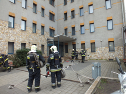 Tűzoltók teljes felszerelésben szerelnek a kollégium előtt