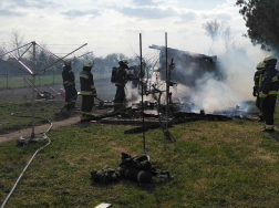 Udvaron a leégett tároló maradványai füstölnek körülötte tűzoltók