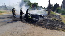  	Tűzoltók oltják a felborult autót