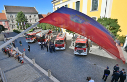 Zászló hátterében tűzoltóautók
