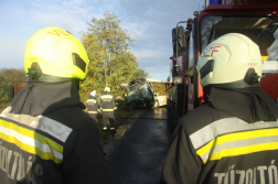 háttal két tűzoltó a háttérben a busz vontatása