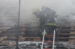 Tűzoltó a tetőn füstben