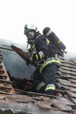 Tűzoltó a tetőn dolgozik