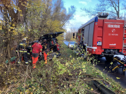 Autó árokban fák között, mellette tűzoltóautó