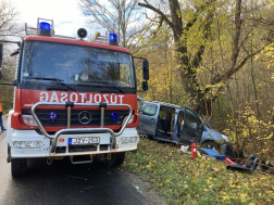 Tűzoltóautó szemből mellette a háttérben a balesetes autó