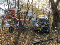 Fák között a balesetes autó mögötte tűzoltóautó