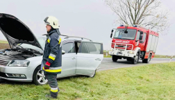 összetört autó előtt tűzoltó