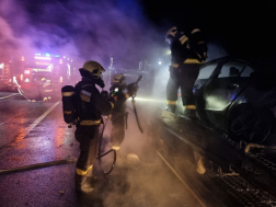 Tűzoltók oltják a füstben a trélert