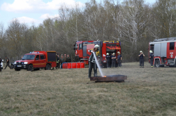 Tálcatüzet olt egy önkéntes tűzoltó háttérben tűzoltó járművek és emberek