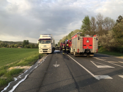 Úton a nyerges vontató mellette tűzoltóautók