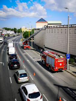 Utcai képen látszik az út szélén álló tűzoltóautó és létraszer